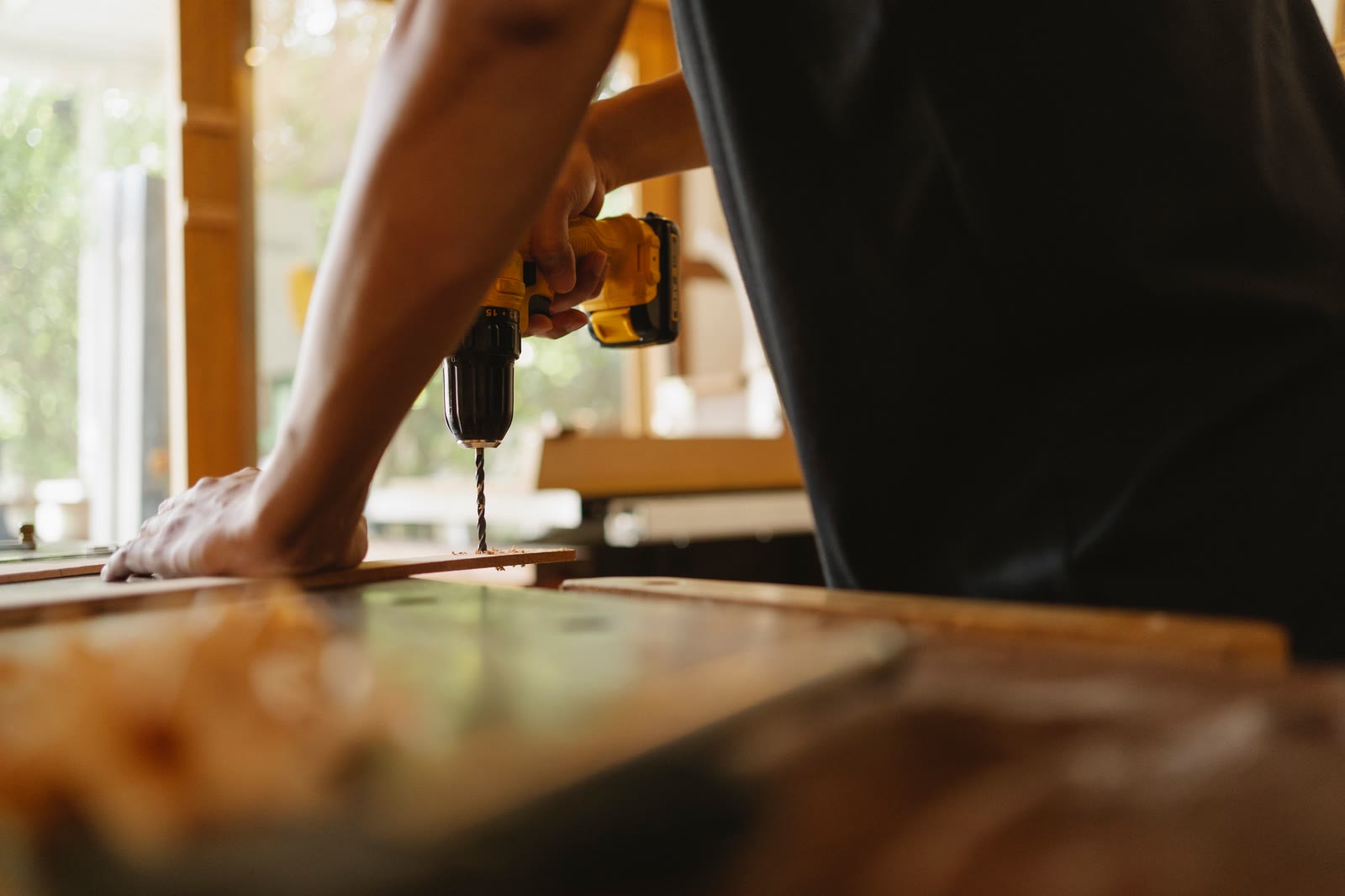 Handwerker bohrt ein Brett an